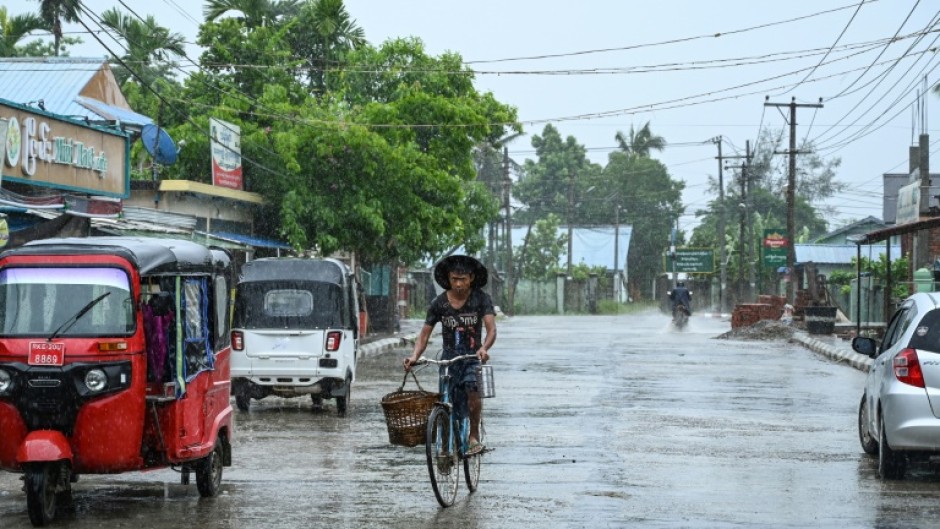 A man rides a bicycle in an almost empty street in Kyauktaw in Myanmar on May 14, 2023, ahead of the expected landfall of Cyclone Mocha