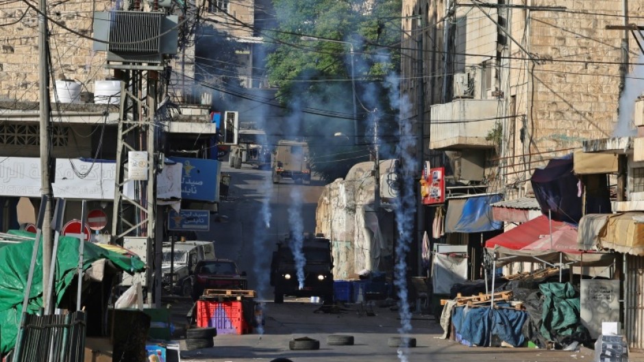 Israeli security forces fire tear gas to disperse Palestinians during a raid in the occupied West Bank city of Nablus