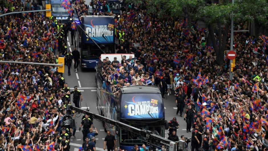 Barcelona players from the men's and women's team paraded through the city on open-top busses on Monday after their title wins