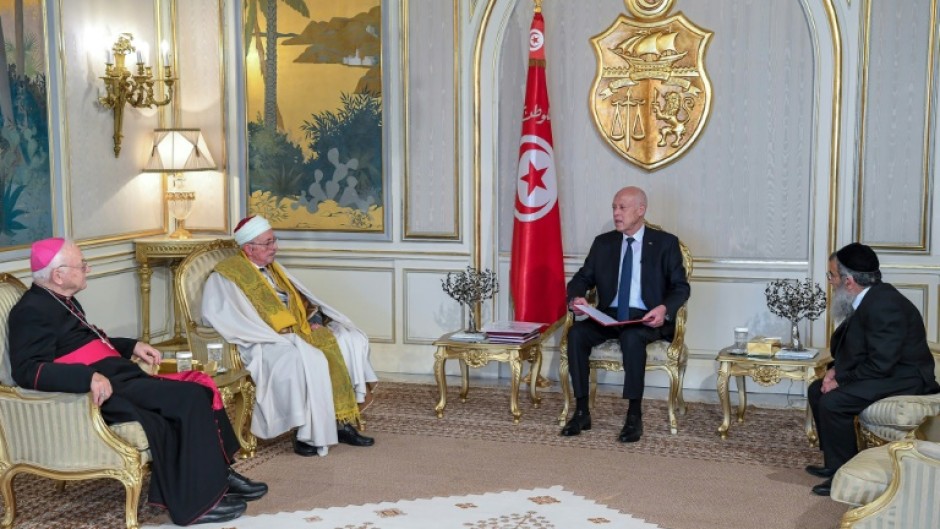 Tunisian President Kais Saied, seated next to the flag, meets Bishop Ilario Antoniazzi, Chief Rabbi Bitten Haiem and Mufti Hichem Ben Mahmoud at the Carthage Palace in Tunis