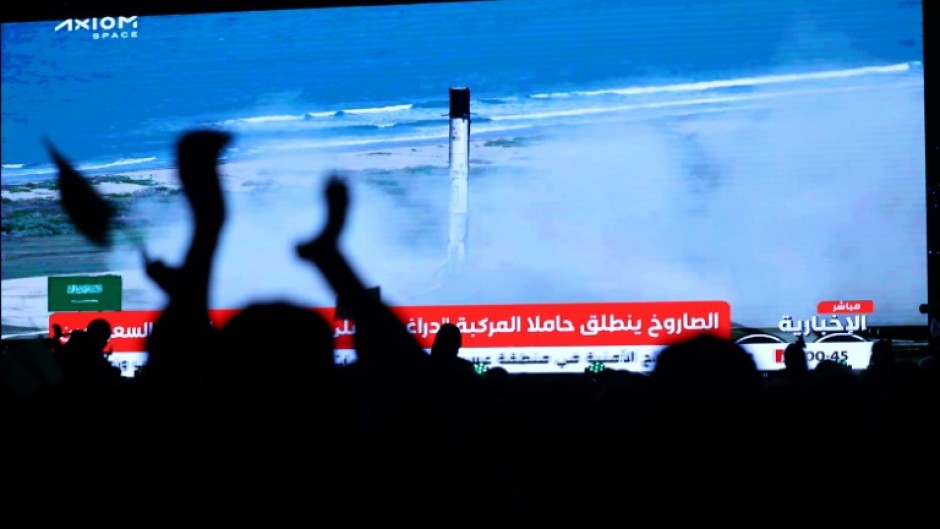 People watch a screen in Riyadh as a SpaceX Falcon 9 rocket carrying the Axiom Mission 2 astronauts lifts off from pad 39A at NASA's Kennedy Space Center in Florida