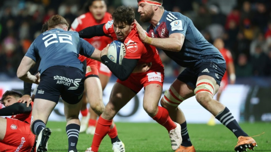 Munster lock Jean Kleyn (R) tackles Toulouse scrum-half Antoine Dupont during a 2023 Champions Cup match.
