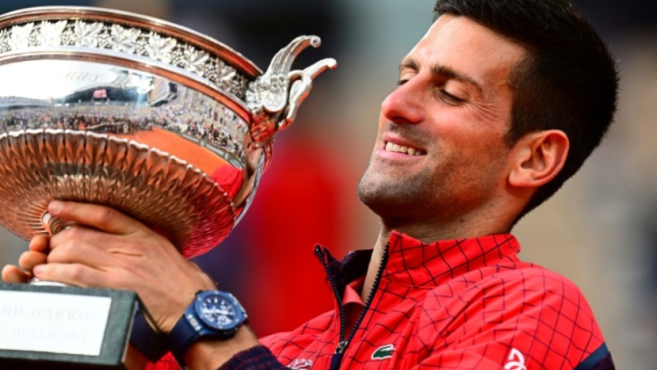 Record-breaker: Novak Djokovic poses with his trophy on Sunday