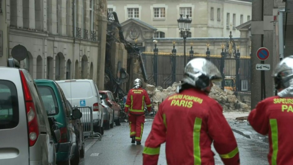 Firefighters and police near the collapsed building in Paris