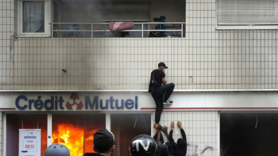 A protester climbs on a building during clashes in Nanterre on Thursday