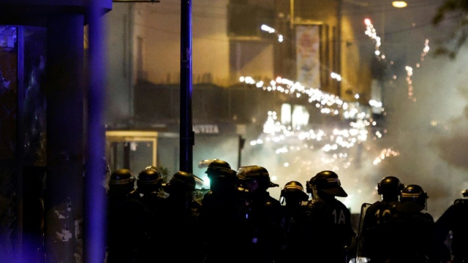 Fireworks explode as police stand by during protests in the northern city of Roubaix