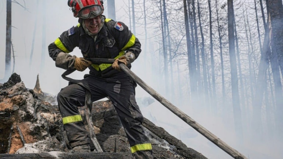 A French firefighter battles a blaze at Lac Larouche in Canada's Quebec Province in late June 