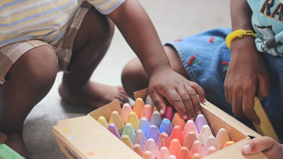 File: Children playing with chalk crayons.