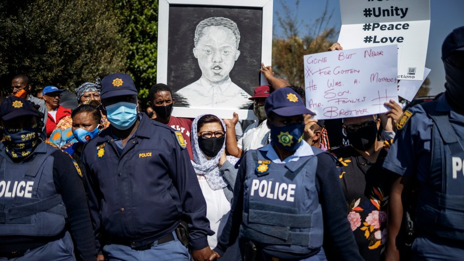 File: Community members hold a placard with an image of Nathaniel Julies in Eldorado Park. AFP/Michele Spatari