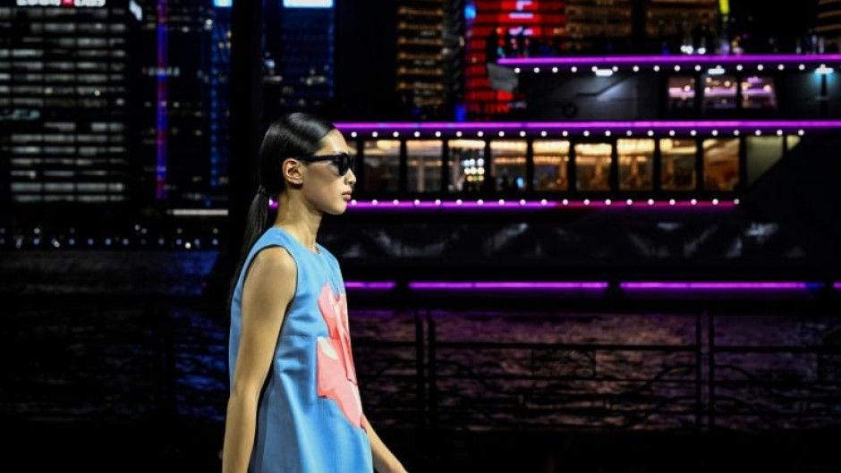 Dozens of models in dark blues and pastels paraded down the riverfront catwalk that took Shanghai's Oriental Pearl Tower as a backdrop