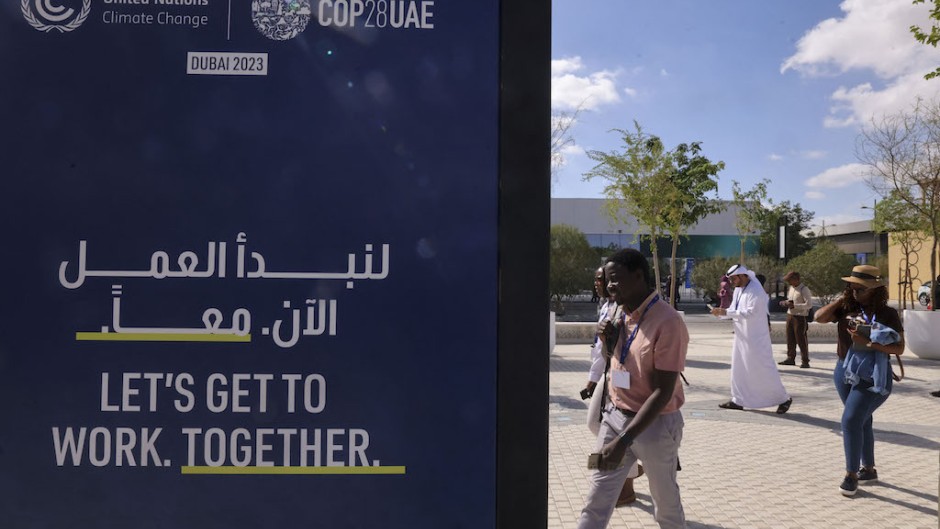 People arrive at the venue of the COP28 United Nations climate summit in Dubai. AFP/Karim Sahib