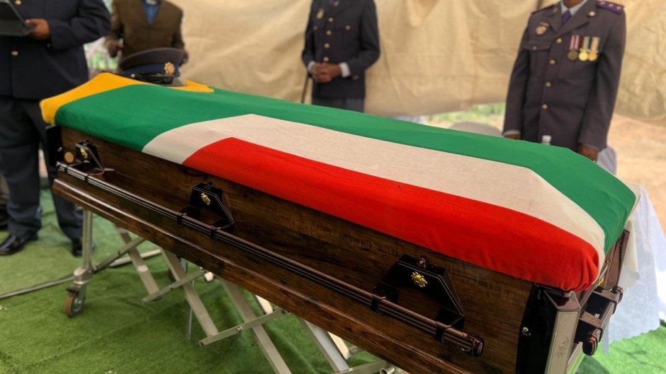 Police officers stand guard over a fallen colleague's casket. Twitter/SAPoliceService