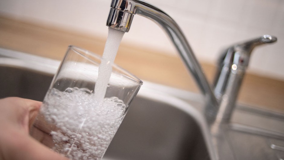 File: A man holds a glass under a running tap. AFP/DPA/Marius Becker