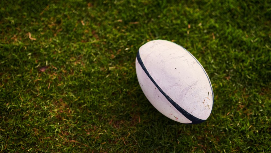 File: A rugby ball on an empty rugby field. GettyImages/PeopleImages