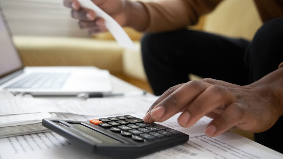 File: A man with a calculator checking bills.GettyImages/fizkes