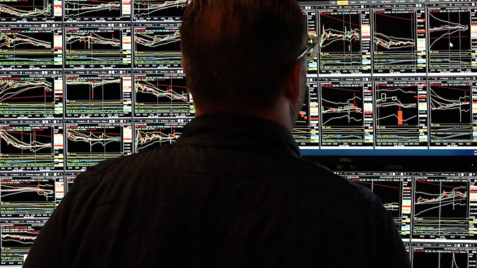 File: A trader looking at stock market graphs. AFP/Timothy A Clary