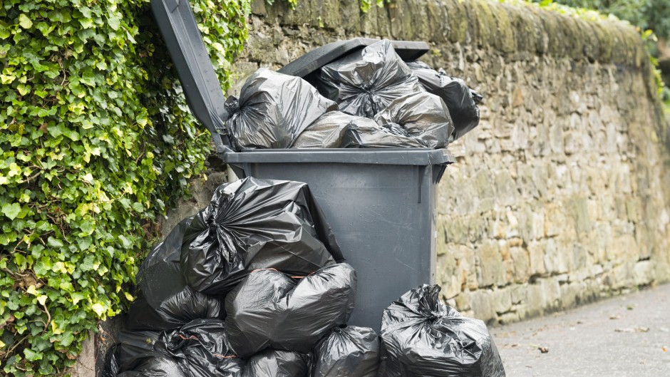 File: A full wheelie bin with rubbish bags overflowing. GettyImages/georgeclerk