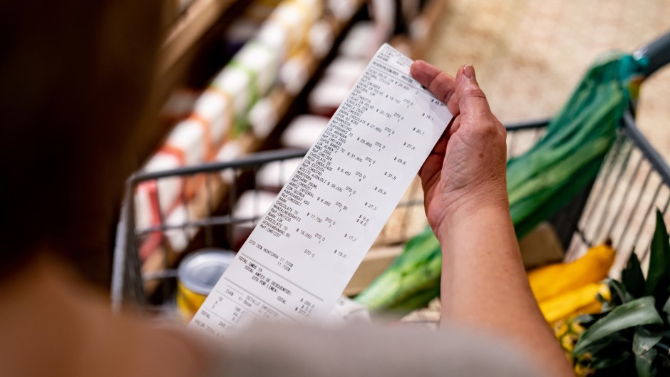 File: A shopper looking at a receipt in a supermarket. GettyImages/andresr