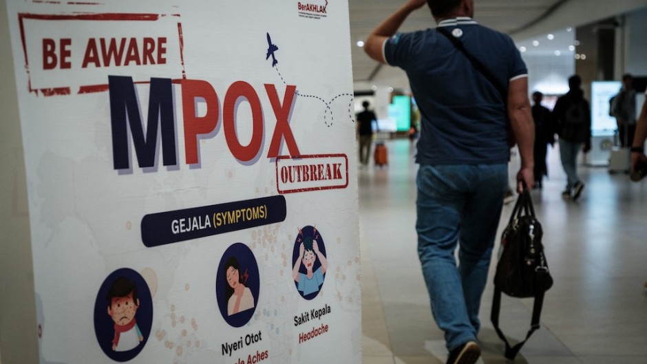 A passenger walks past a banner informing about MPOX at Soekarno-Hatta International Airport in Tangerang. AFP/Yasuyoshi Chiba