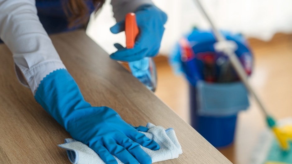 File: A domestic worker cleaning a desk. GettyImages/Dusan Sapic