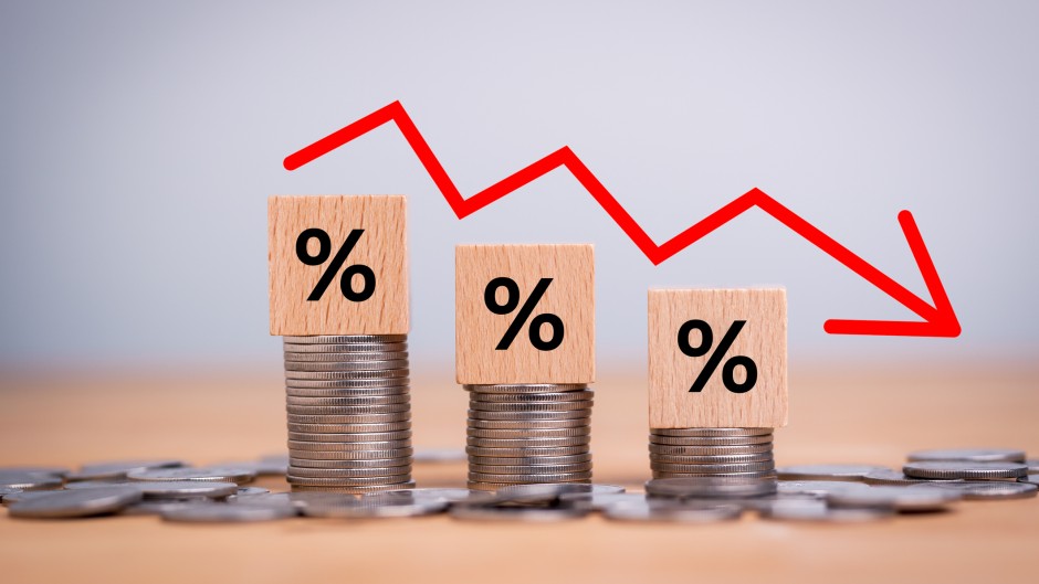 File: A percentage sign on coins indicating a downwards trend of inflation. Getty Images/Mongkol Onnuan