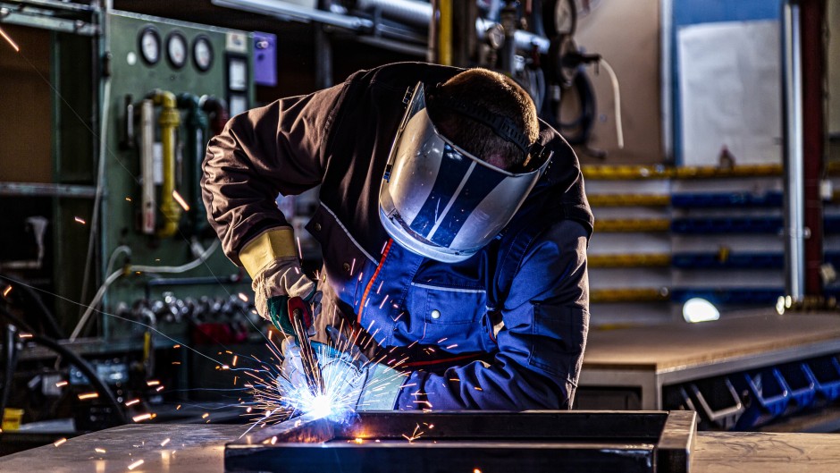 File: An industrial worker welding at the factory. Manufacturing sector. GettyImages/chriss_ns