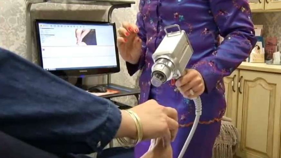 A skin screening machine held by a professional 