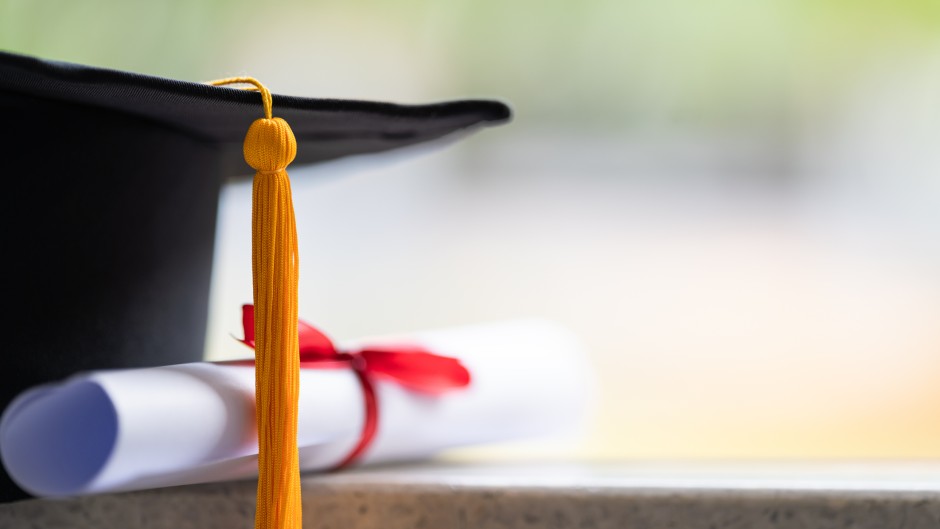 File: Close-up of a mortarboard and degree certificate. GettyImages/sengchoy