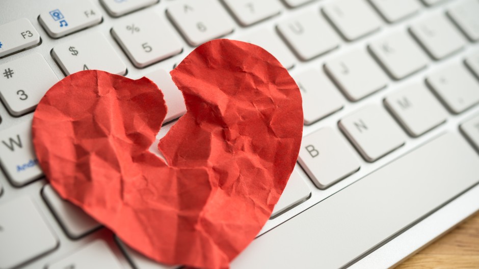 File: A broken heart paper on white keyboard computer background. GettyImages/Pla2na