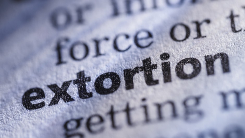 The word extortion in a dictionary. GettyImages/JLGutierrez