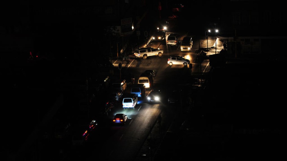 File: Vehicles travel along a darkened street without lighting. Leon Sadiki/Bloomberg via Getty Images