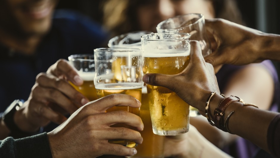 File: A group of friends toasting beer glasses. GettyImages/The Good Brigade