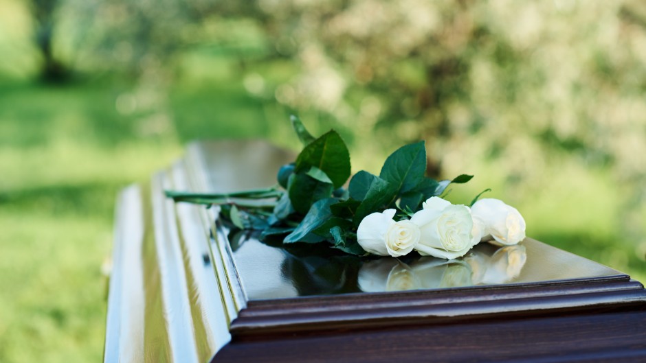 File: A bunch of roses on top of a coffin. GettyImages/shironosov