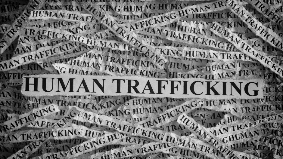 File: Torn pieces of paper with the words Human Trafficking. GettyImages/Professor25