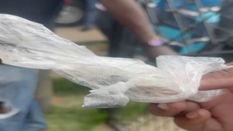 A resident holds a packet of food sold at a spaza shop.