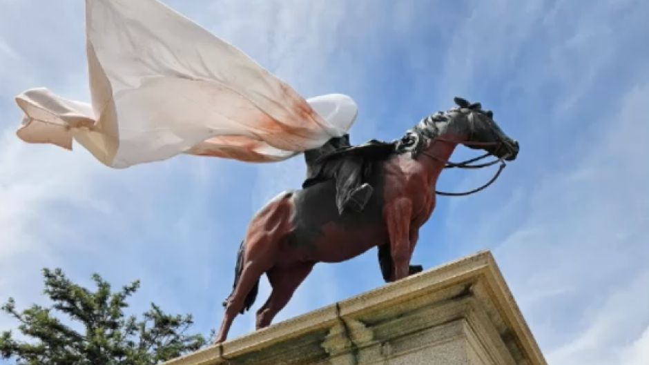 The statue of Rhodes on a horse was covered in red with a white cloth over his face. Supplied