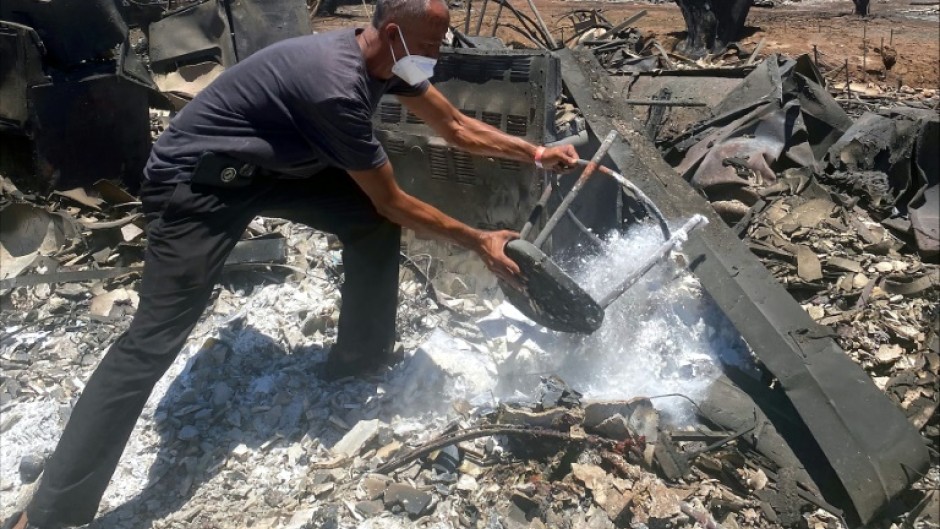 Anthony La Puente, 44, recovers items from his house that was burned in a wildfire in Lahaina, Hawaii