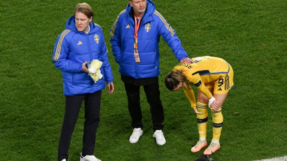 Sweden coach Peter Gerhardsson (C) consoles captain Kosovare Asllani after the World Cup semi-final defeat against Spain