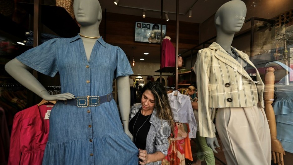 A saleswoman dresses a plus size mannequin at a store in Sao Paulo, Brazil