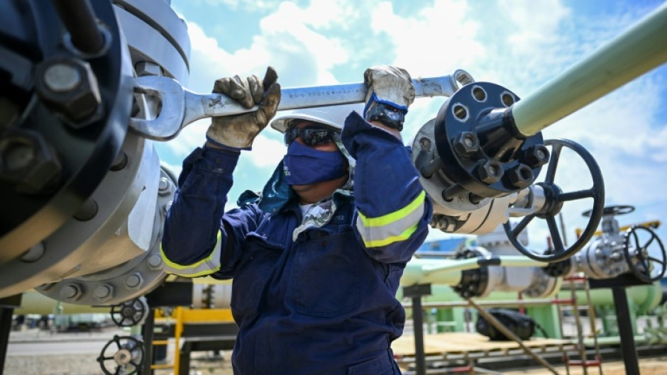 A worker fixes a pipeline at an oil facility in the town of Acacias in Colombia in February 2023