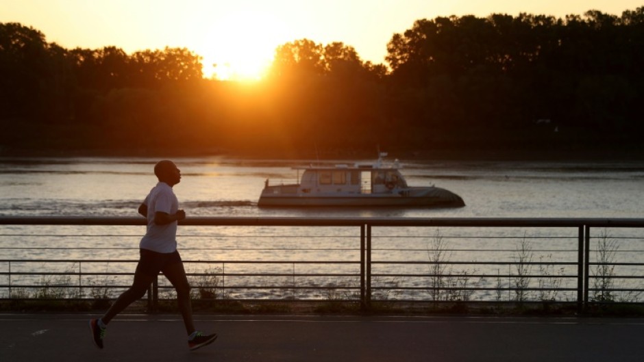 A man jogs along the docks at sunrise to avoid the heat, in Bordeaux, southwestern France.