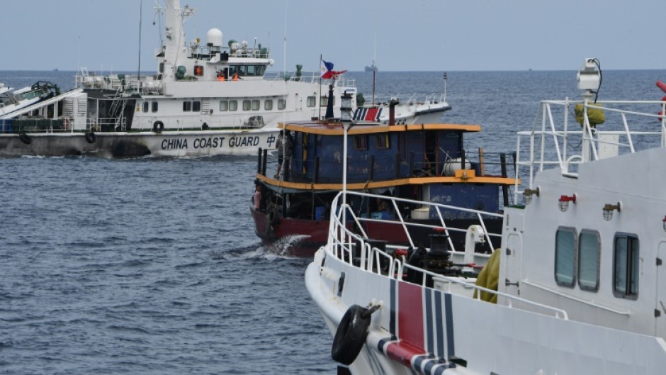 Chinese coast guard ships corrall a Philippine on a resupply mission to a remote navy ship in the disputed South China Sea