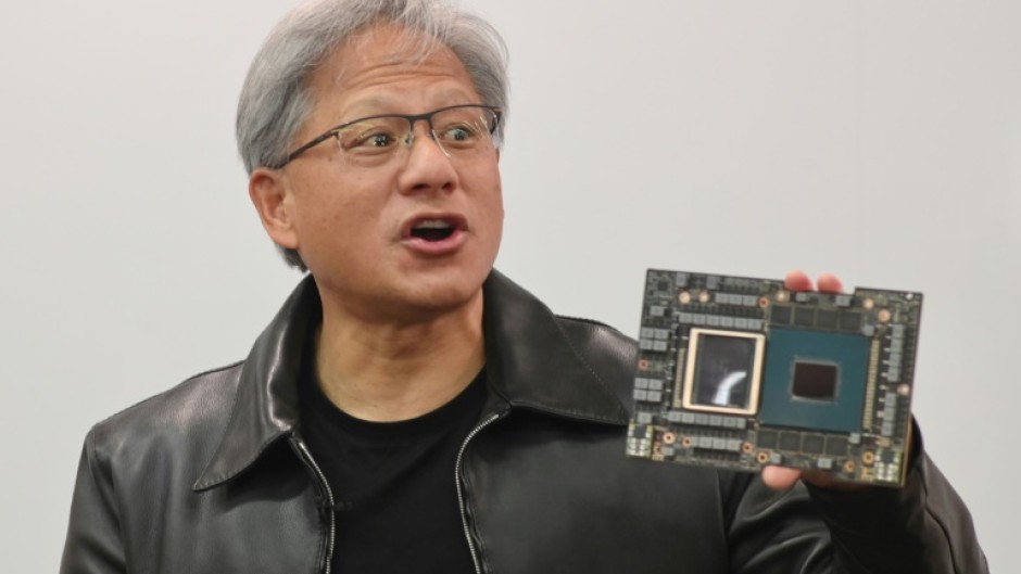 Nvidia CEO Jensen Huang with one of the firm's processors -- prized for building AI applications