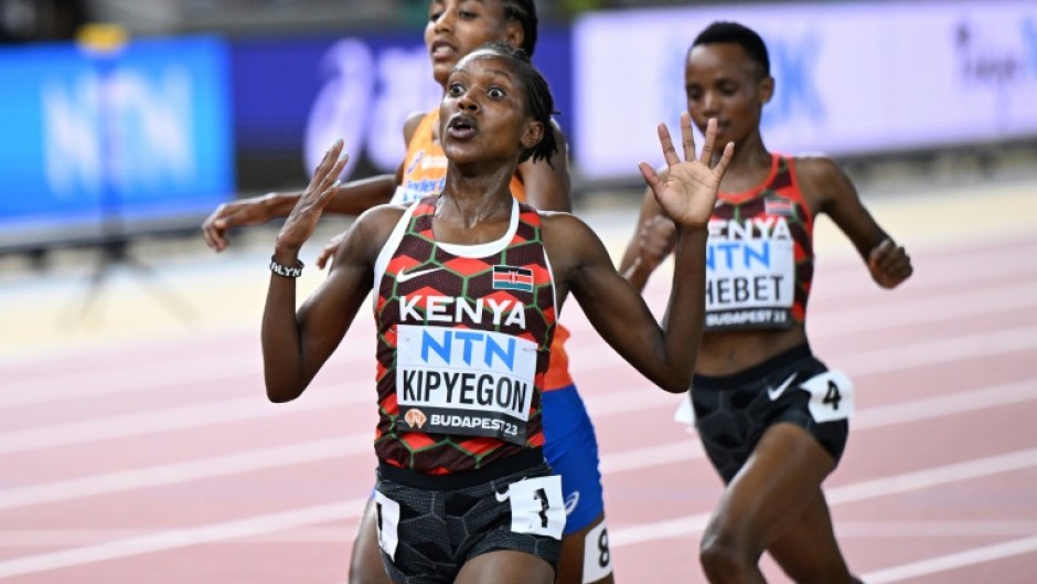 Kenya's Faith Kipyegon (C) reacts as she crosses the finish line to win the women's 5000m final ahead of Netherlands' Sifan Hassan (L) and Kenya's Beatrice Chebet (R)