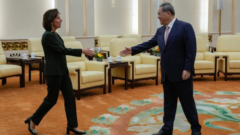 China's Premier Li Qiang (R) greets US Commerce Secretary Gina Raimondo at the Great Hall of the People in Beijing on August 29, 2023.