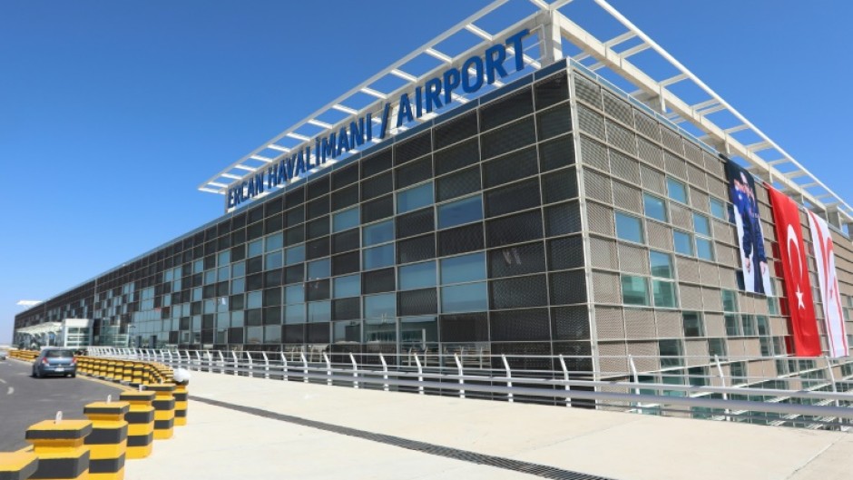 Flags of Turkey and breakaway North Cyprus hang on the facade of the new terminal for its inauguration