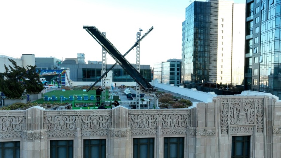 Workers install a large X on the roof of the former Twitter headquarters on July 28, 2023 in San Francisco