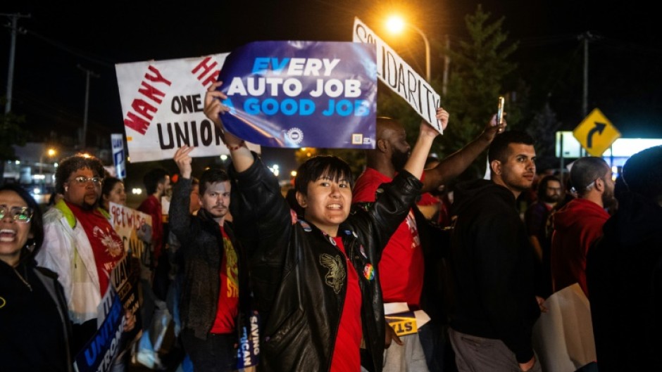 Members of the UAW (United Auto Workers) picket and hold signs outside of the UAW Local 900 headquarters across the street from the Ford Assembly Plant in Wayne, Michigan on September 15, 2023