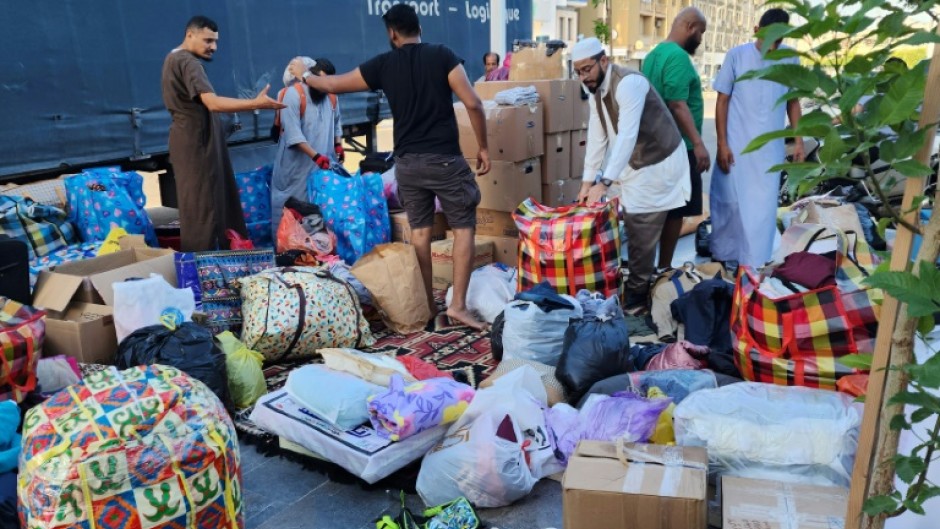 Libyans donate clothes and blankets at a collection point in the capital Tripoli for transport across the nation's political divide to the flood-hit city of Derna