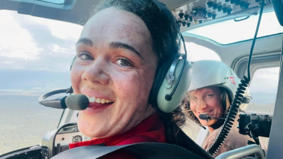 This handout photo dated July 13, 2022, shows firefighter Kara Galbraith (L), in a helicopter Carmacks, Yukon, Canada, flying to a fire. Galbraith was deployed with an Initial Attack Crew to help with the fires in the Yukon